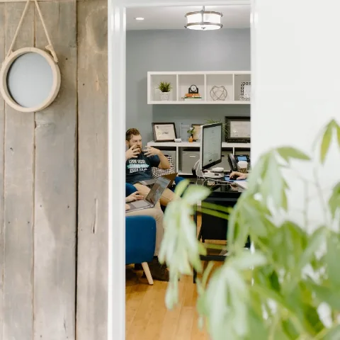 A team member at work, seen through the doorway of a studio office