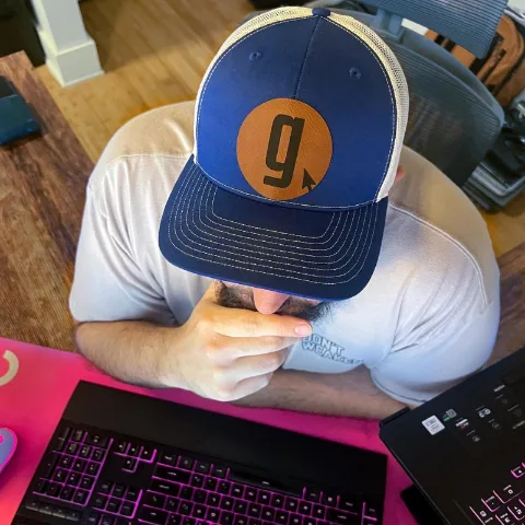 A team member in a Goebel Media cap working at a keyboard