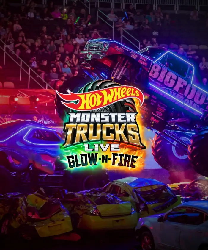 The Hot Wheels Monster Trucks Live Glow-N-Fire logo over a neon-lit arena crowd and monster truck